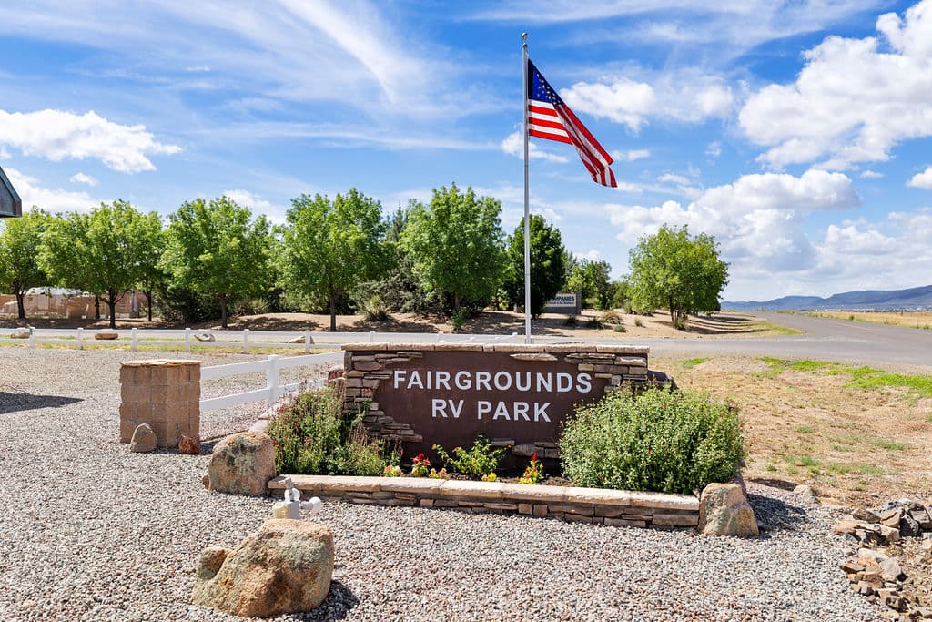 The Fairgrounds RV Park entrance sign beneath an American flag.